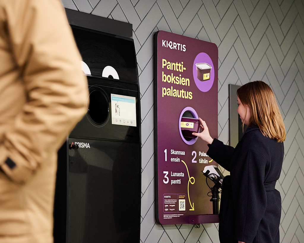 Nainen palauttaa Kiertis-rasiaa automaattiin